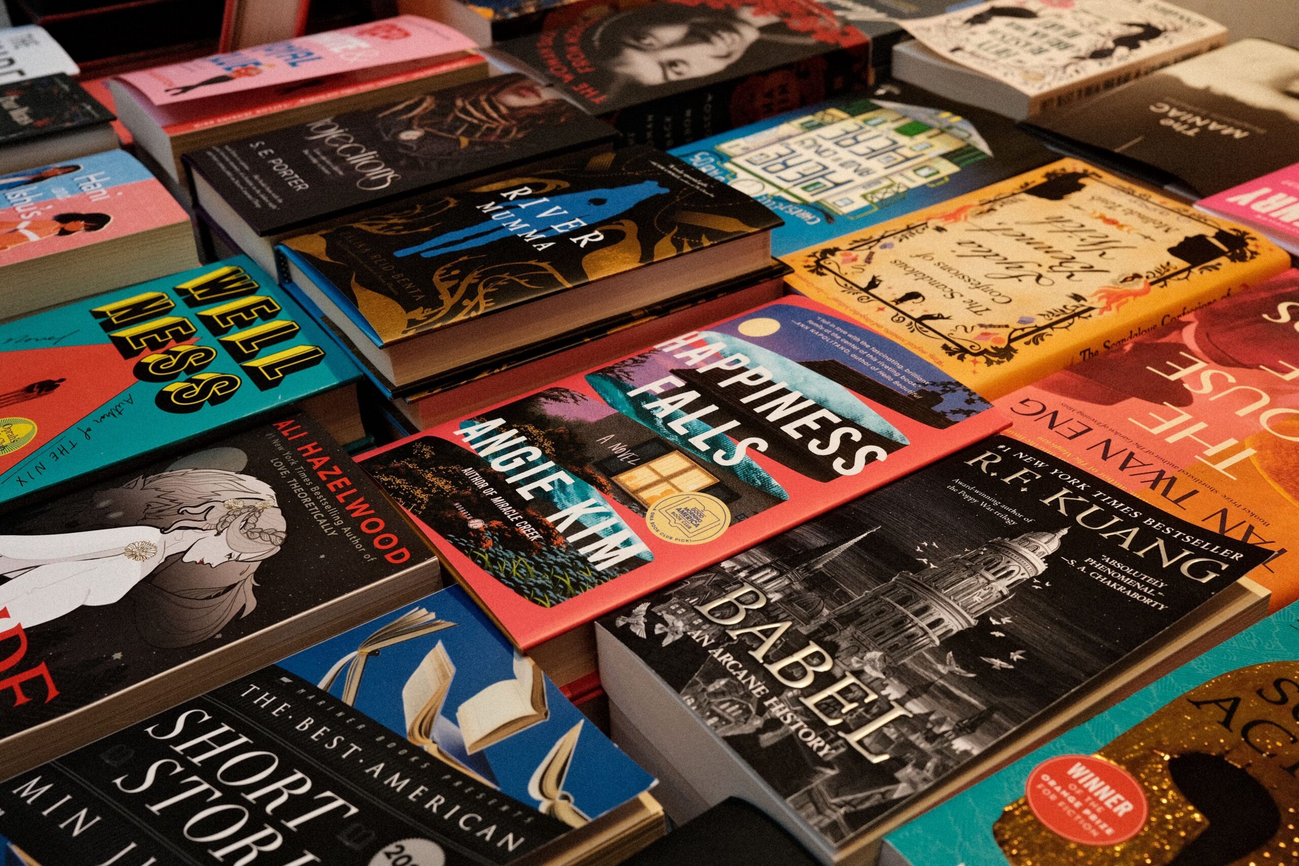 Capas de todos os gêneros se sobrepõem numa mesa de livros, convidando a folhear sem pressa
