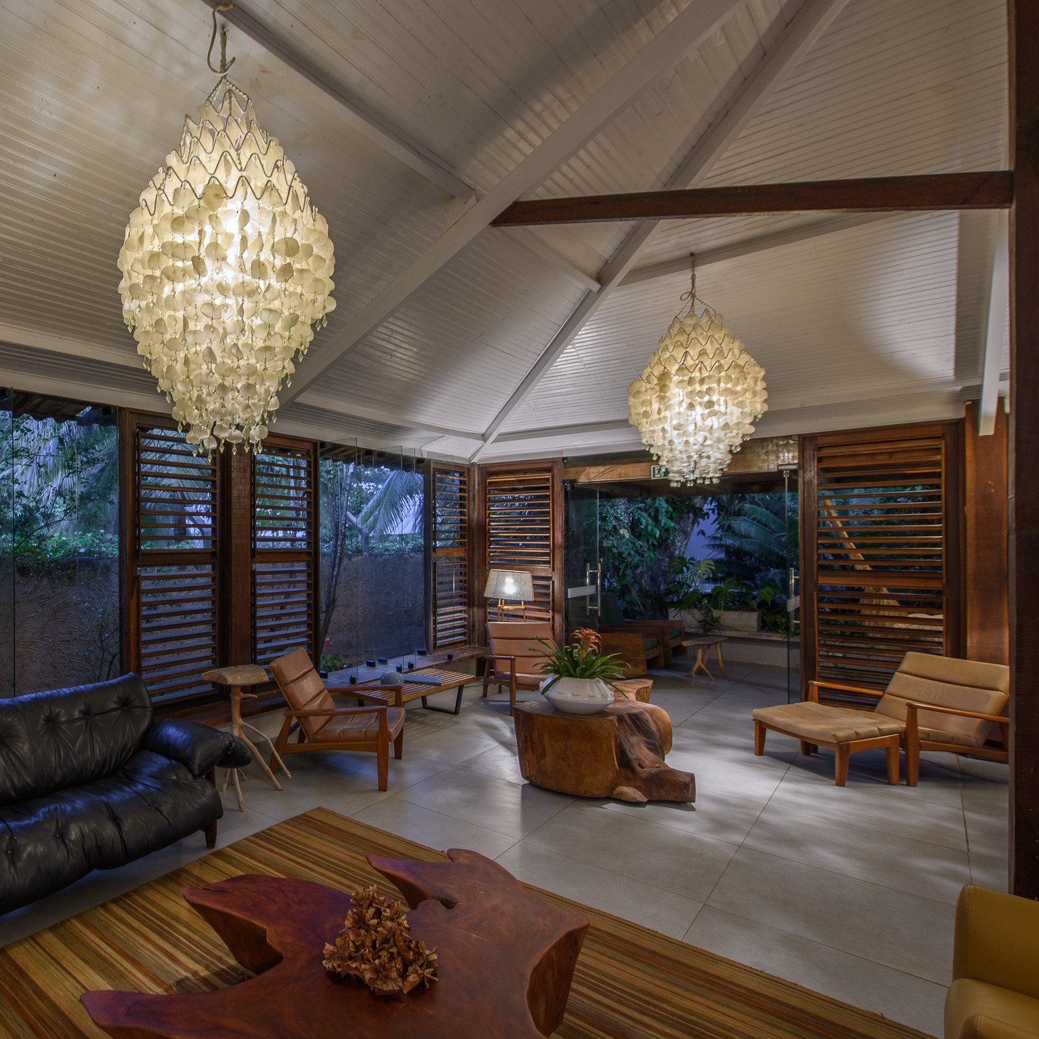 Sala de estar da Pousada do Toque, com luminárias artesanais e mobiliário de madeira, que reforça a hospitalidade de alto padrão