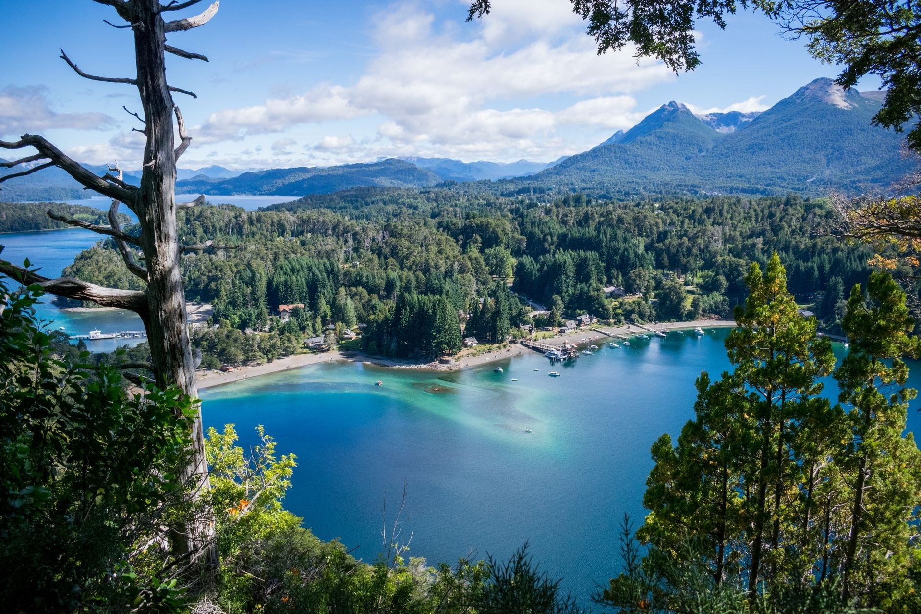 Vista de baía no lago patagônico, cercada por floresta e montanhas, cenário típico da região de Villa La Angostura
