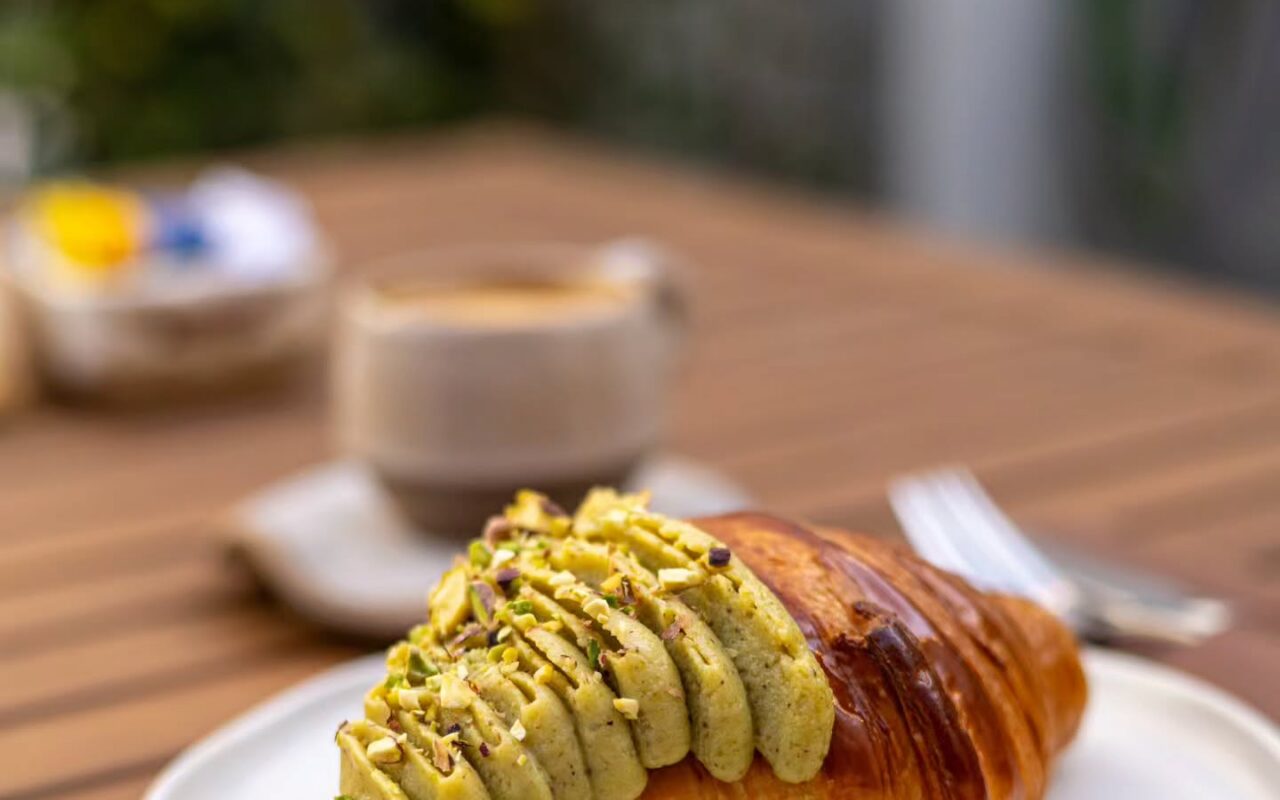 Croissant de pistache da Lê Croá, na Jatiúca, servido com café