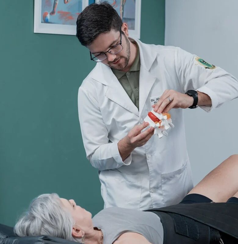 Fisioterapeuta orienta paciente sobre a estrutura da coluna durante sessão de reabilitação e alívio de dores