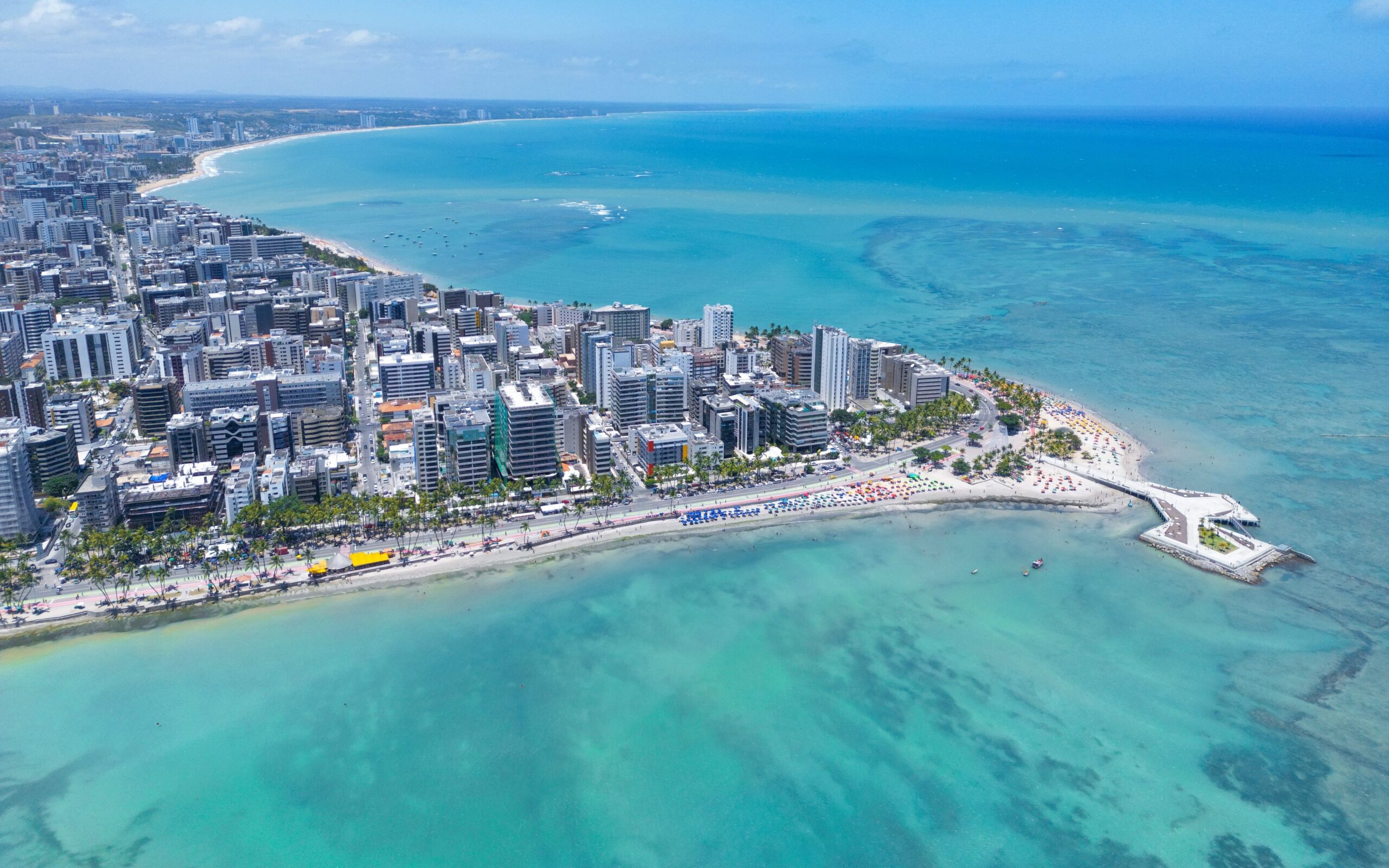 Edifícios alinhados à beira-mar desenham a silhueta vertical de uma cidade que cresce olhando para o oceano