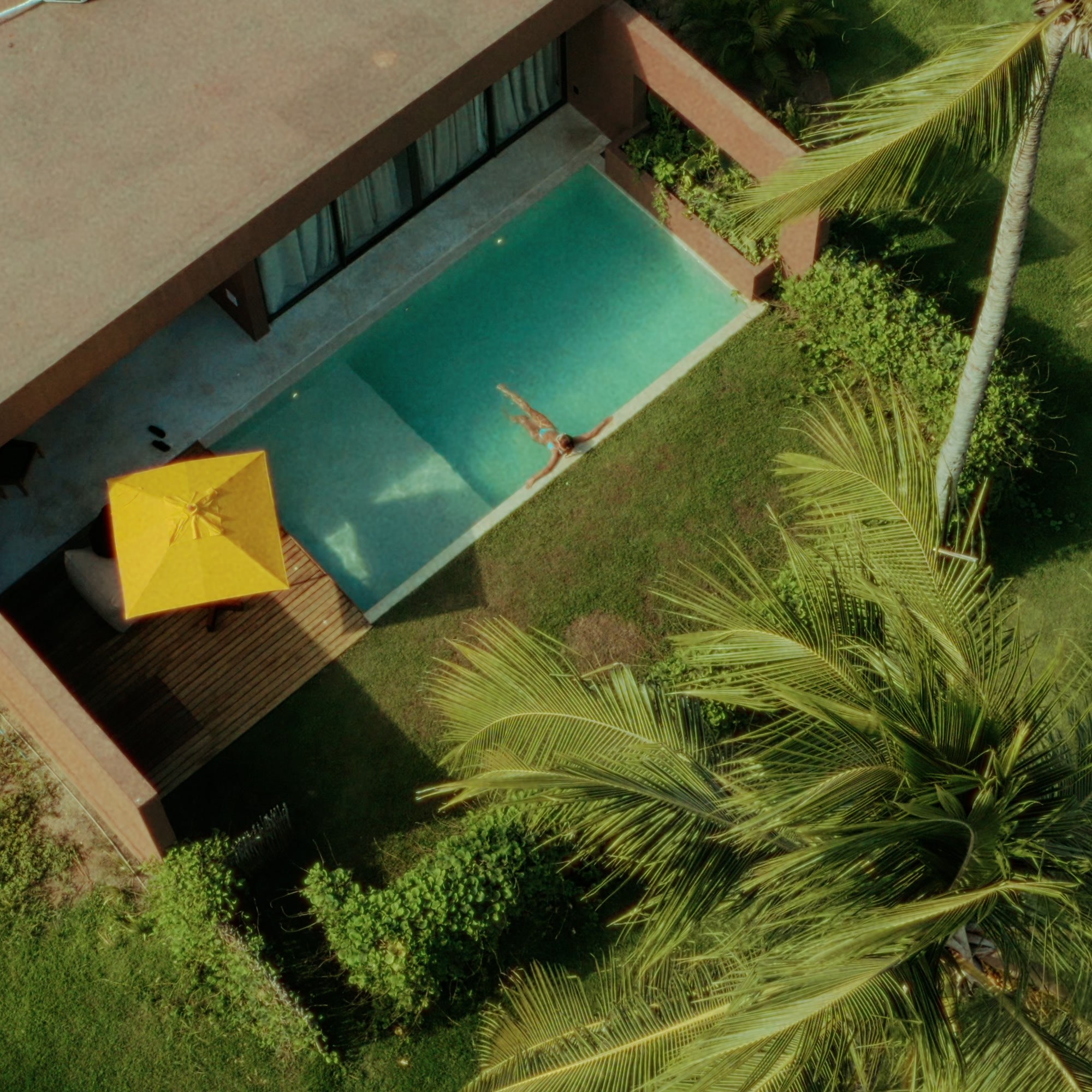 Piscina cercada por jardim e coqueiros em hospedagem de alto padrão no litoral alagoano, cenário da experiência de hospedagem do evento