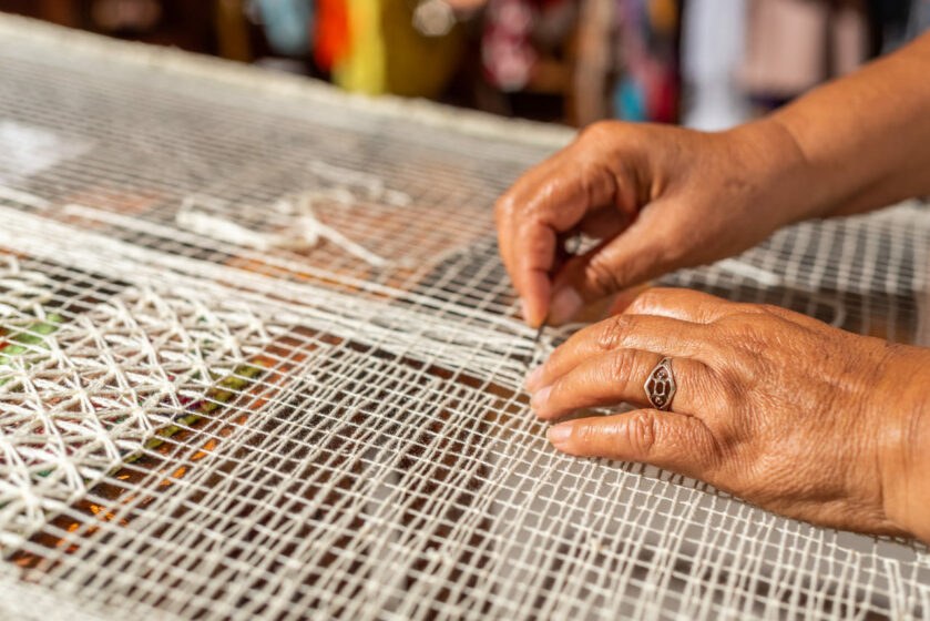Artesã produzindo renda filé, destacando a rica tradição cultural valorizada na mostra sobre Marechal Deodoro