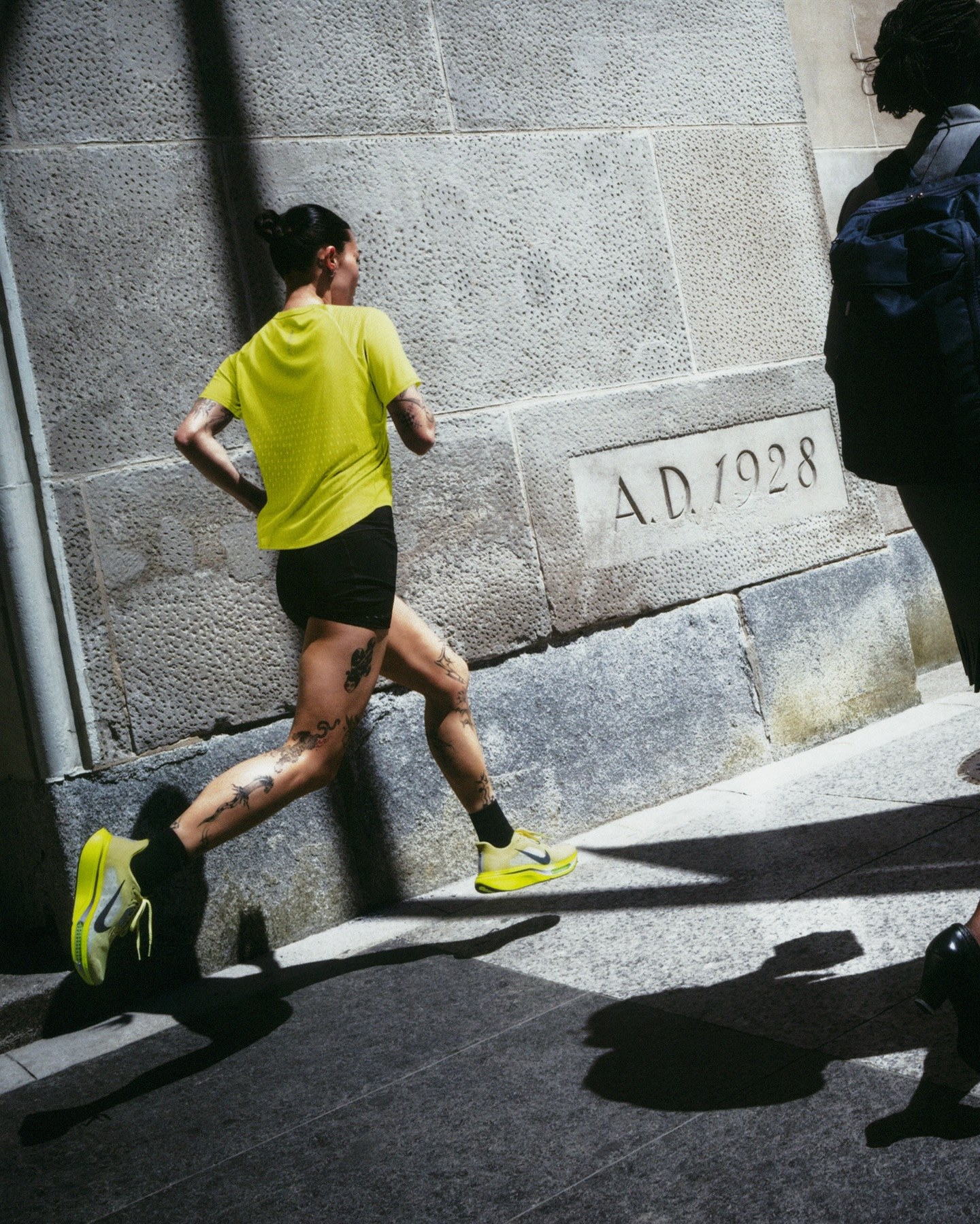 Corredora em ação nas ruas com tênis de corrida Nike amarelo-neon, linha de performance da marca