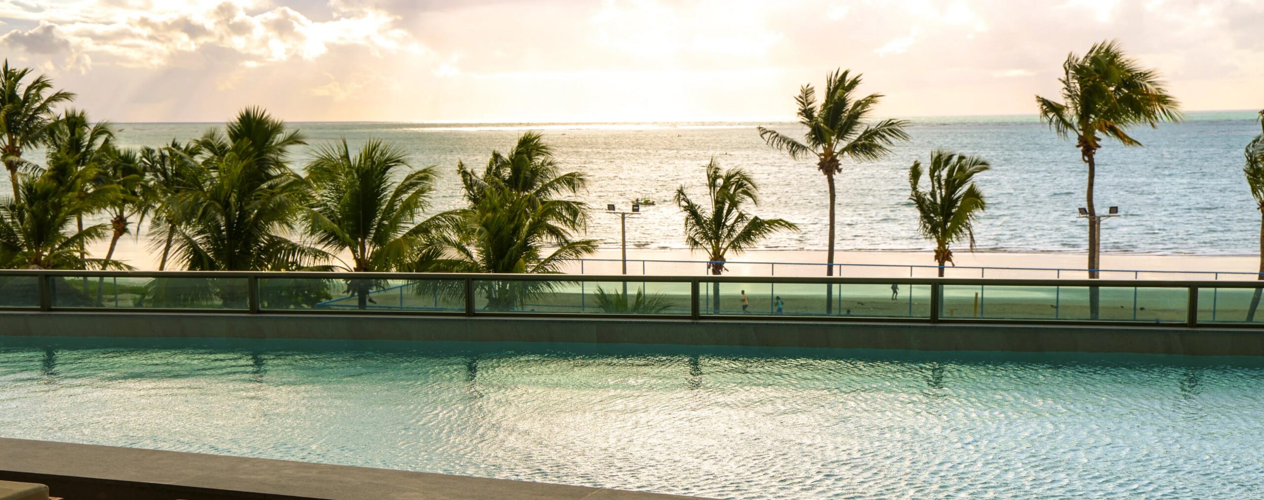 Vista da piscina do SAIS Beach Living Hotel para a orla, espaço dedicado ao descanso e contemplação