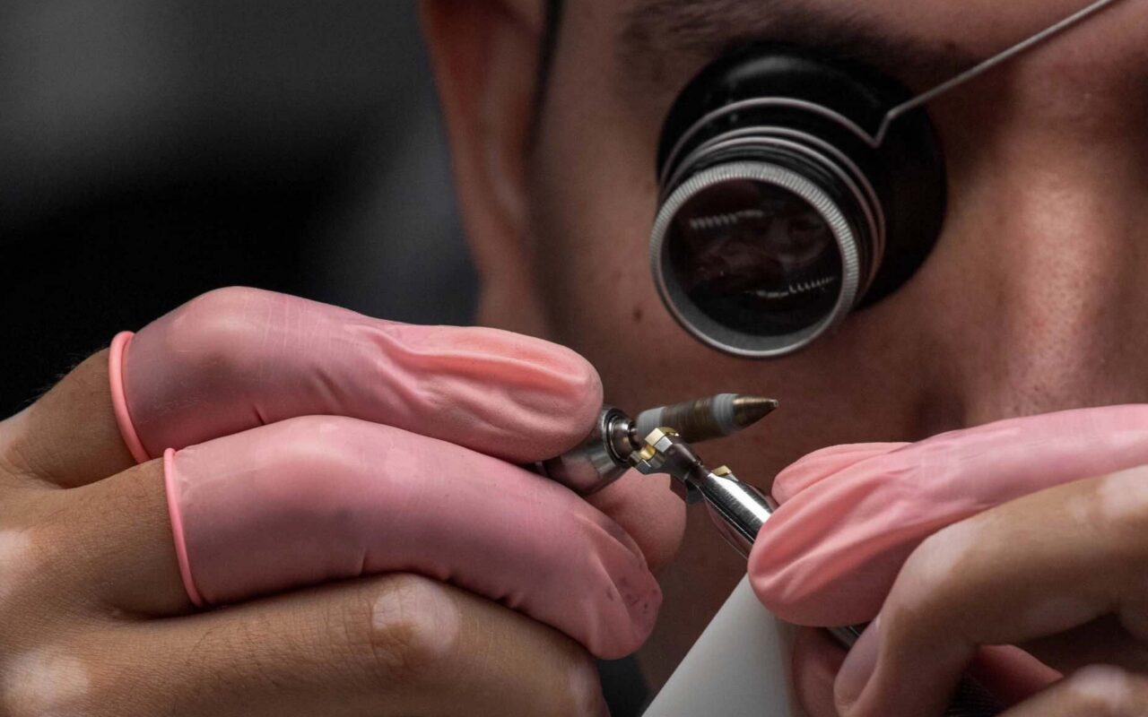 Artesão trabalhando em detalhe de alta relojoaria, destacando o cuidado manual da Patek Philippe