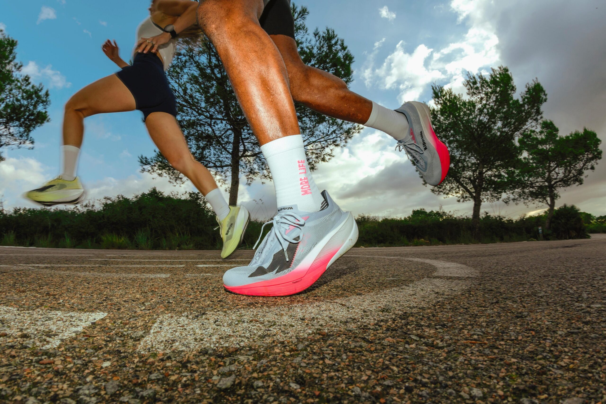 Corredores em movimento com tênis de corrida de solado rosa, em imagem de divulgação que ilustra o tema do calçado com sensor de desgaste