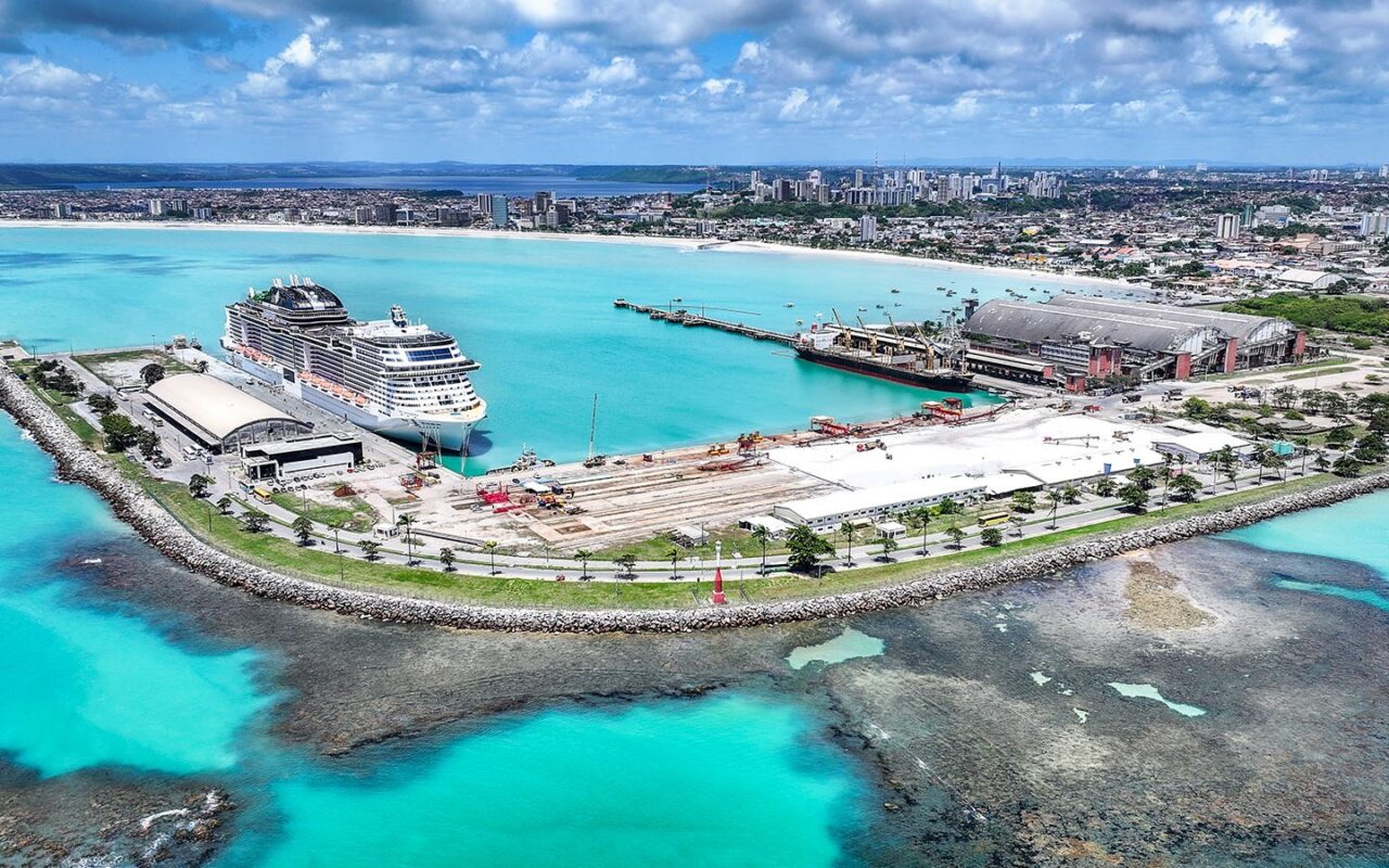 O píer avança sobre águas turquesa, com a cidade se estendendo ao fundo