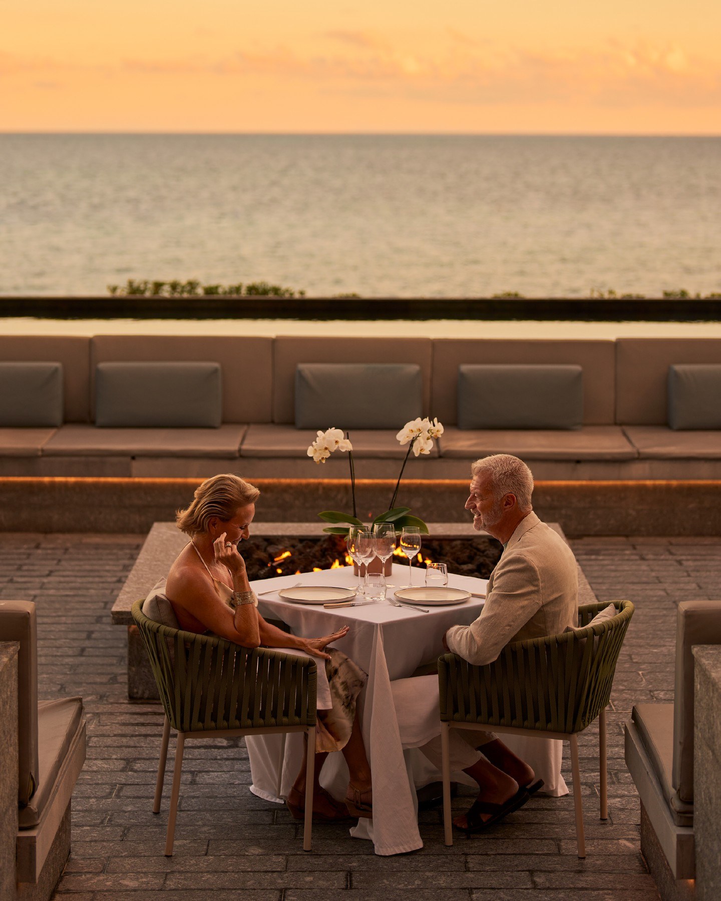 Casal janta em ambiente gastronômico ao ar livre com vista para o mar no Waldorf Astoria Riviera Maya